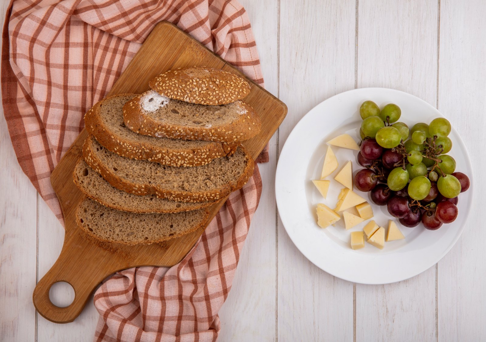 Tranches de pain complet aux graines, cubes de fromage et raisins pour le goûter