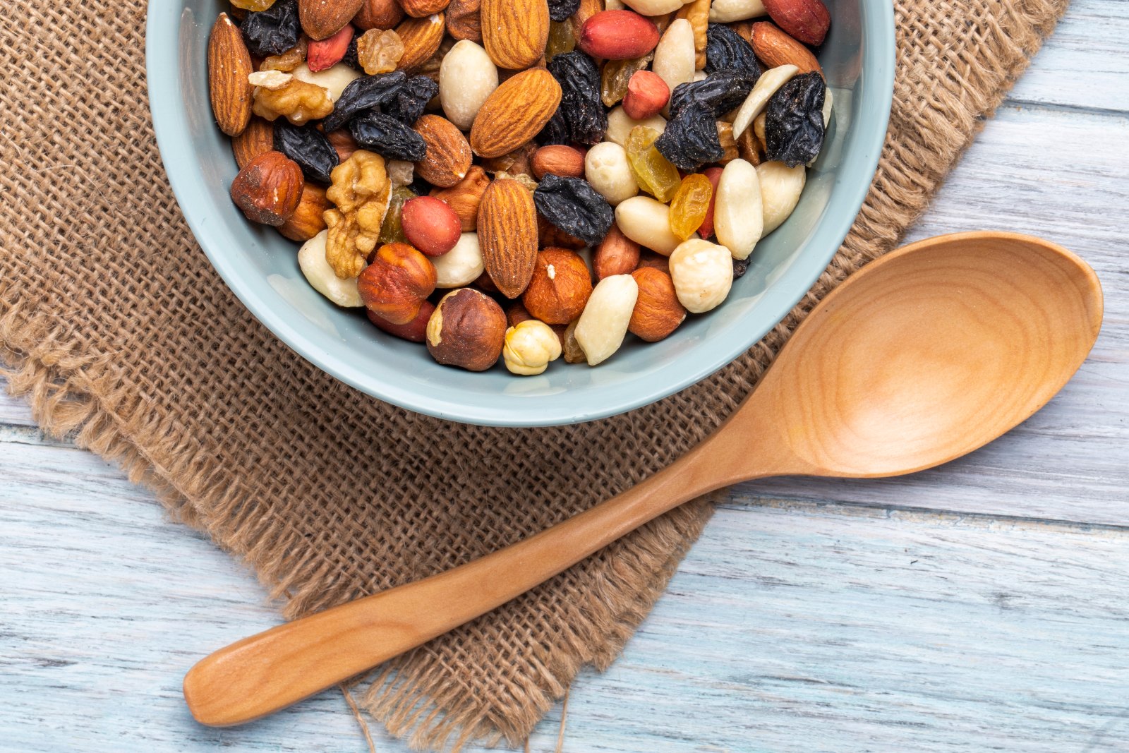 Bol d’amandes, noix, noisettes et raisins secs, à consommer avec mesure