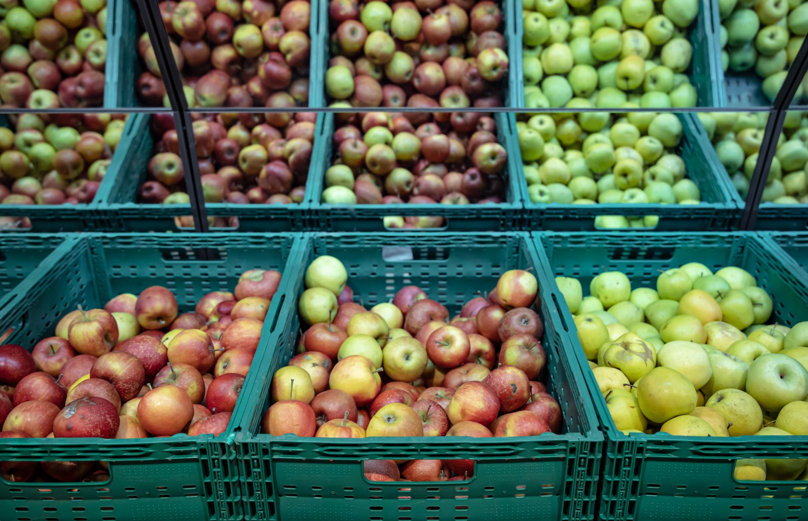 Cagettes de pommes rouges et vertes au rayon fruits d'un magasin
