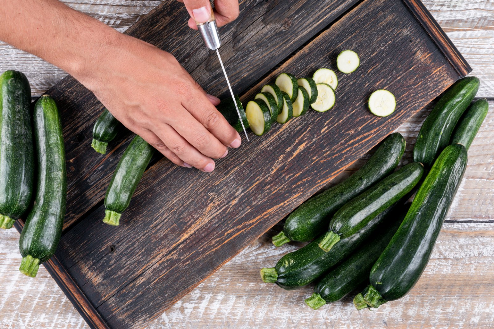 Bloc préparation : courgettes coupées en rondelles sur une planche en bois