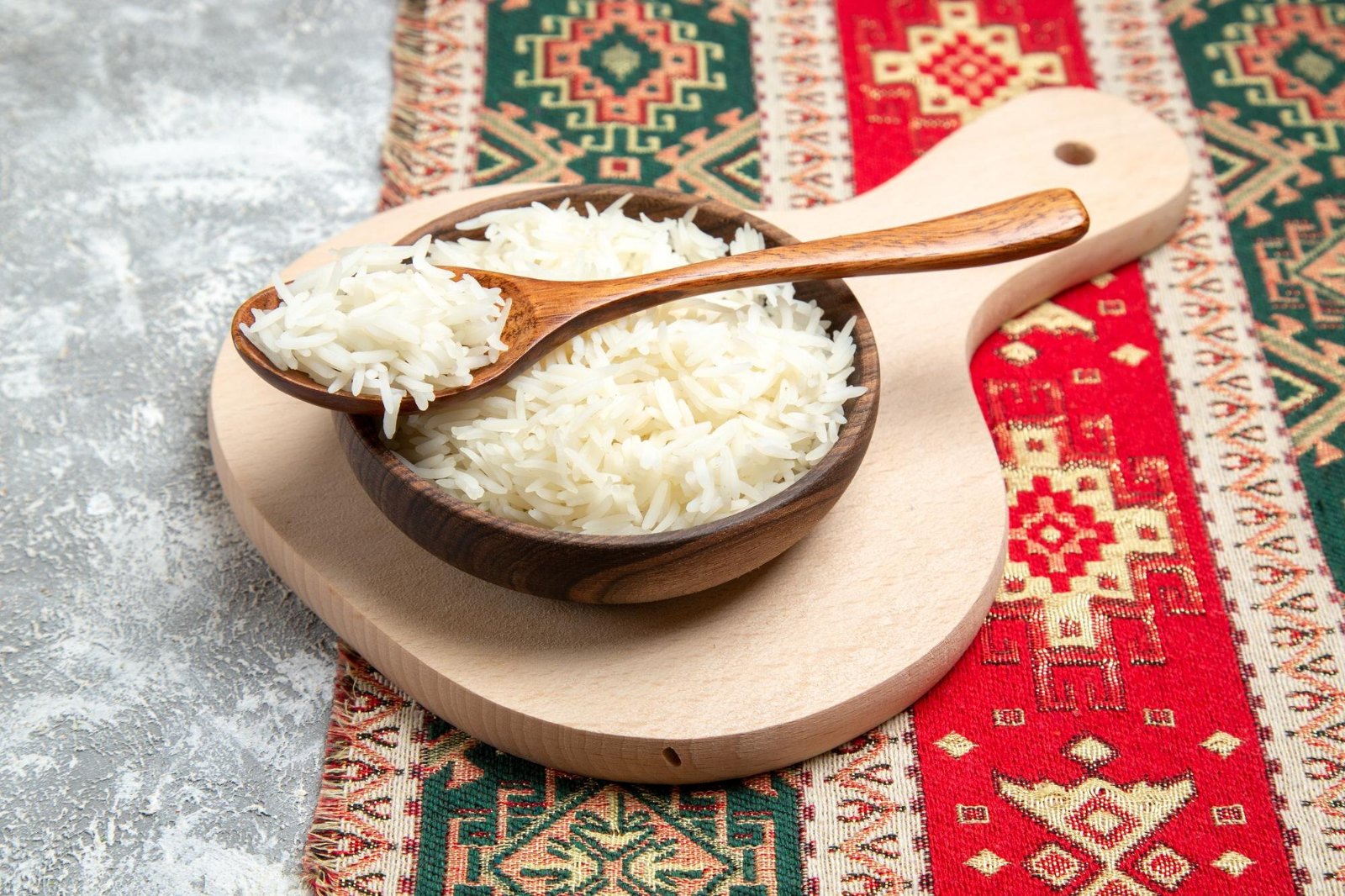 Bol de riz blanc cuit et cuillère en bois : le riz, l'un des cinq piliers quotidiens du système