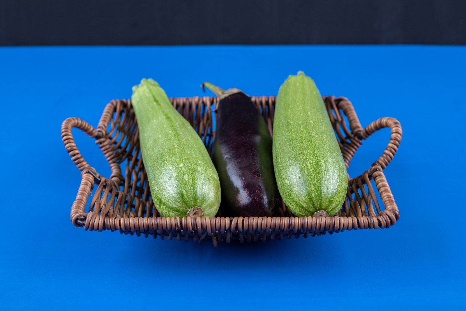 Courgettes et aubergine dans un panier : les légumes de base d'un menu de la semaine