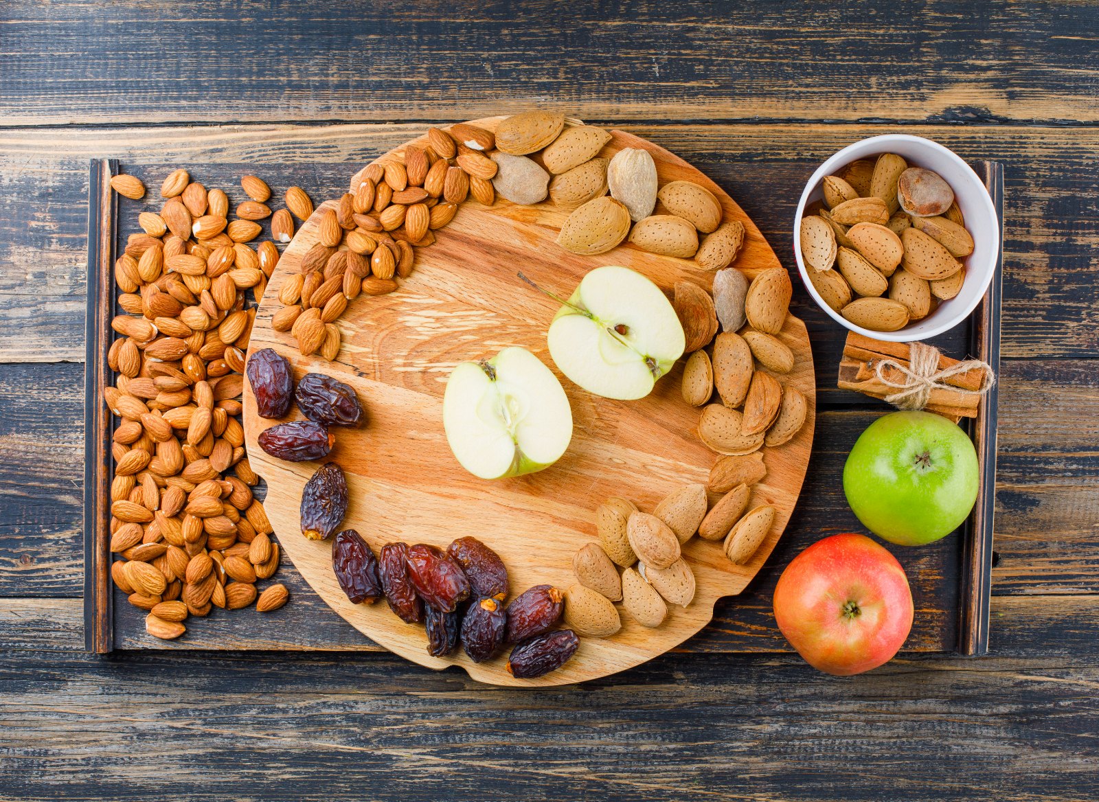 Collation préparée à l'avance : amandes, dattes, pomme et bâtons de cannelle