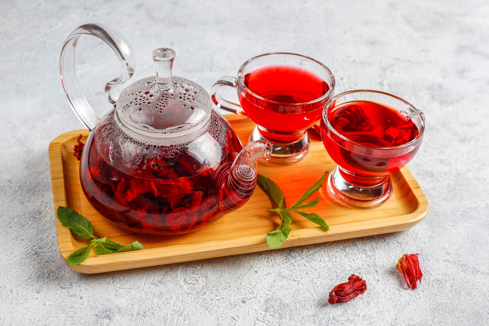 Théière et tasses de karkadé (infusion d'hibiscus) sur un plateau en bois