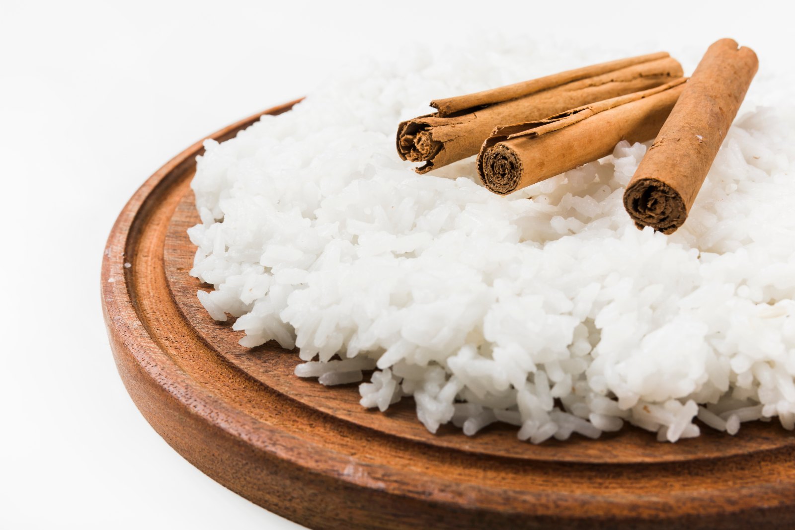 Riz blanc cuit avec des bâtons de cannelle sur une planche en bois