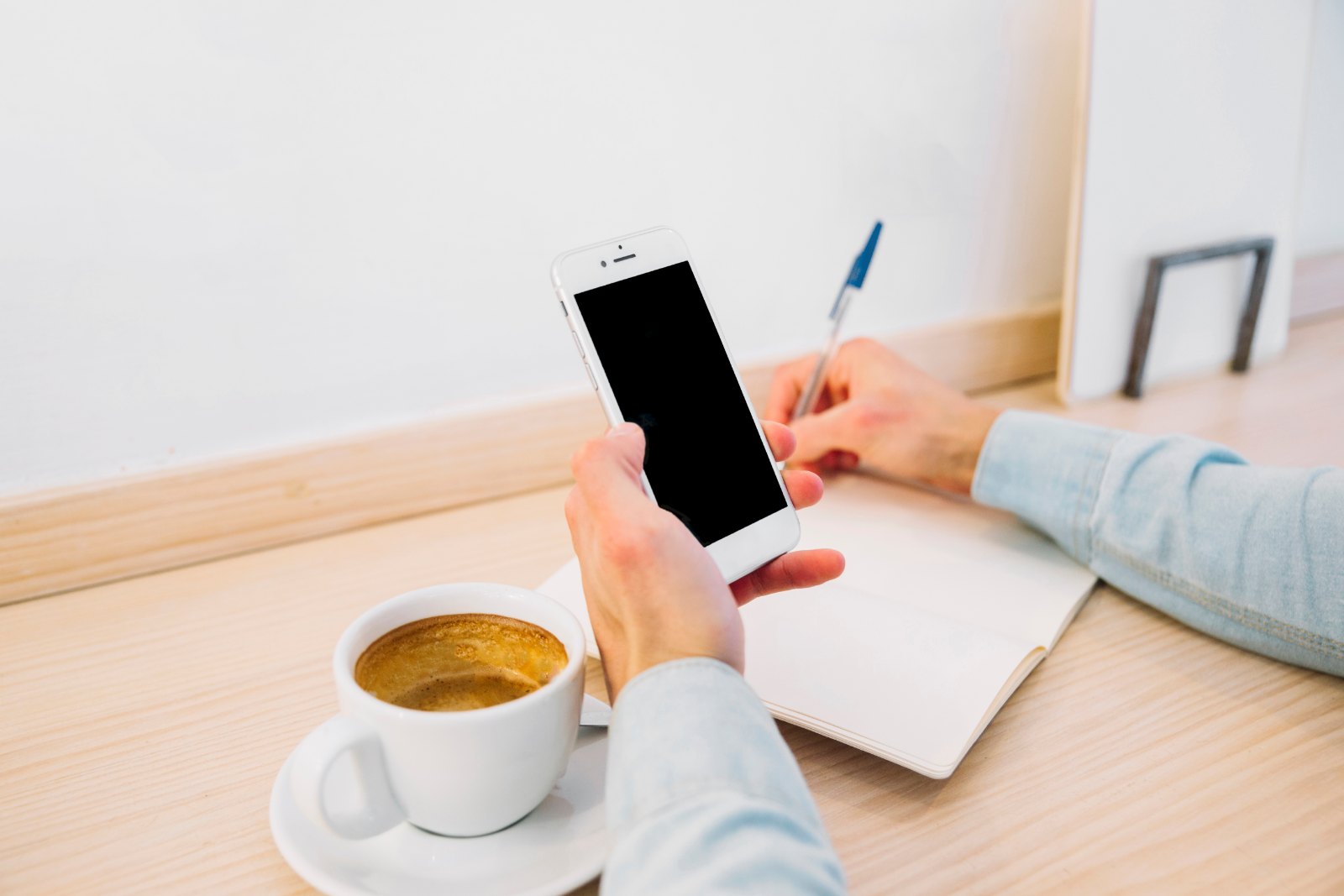 Consulter une fiche aliment sur son téléphone, carnet et café noir à côté